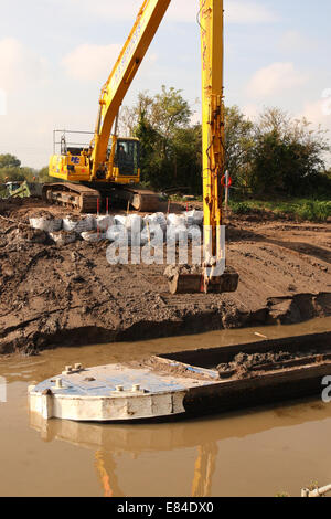 Burrowbridge, Somerset, UK. 30th September, 2014.  Dredging continues along the River Parrett on the Somerset Levels. River silt from mid channel of the Parrett is transferred by barge before offloading onto tractor & trailers for spreading on local fields. Stock Photo