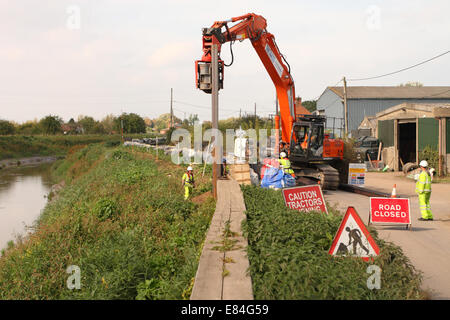 Burrowbridge, Somerset, UK. 30th September, 2014.  Environment Agency contractors install steel piling sheets to reinforce the river bank of the River Parrett as part of their flood prevention work to help protect the Somerset Levels from flooding. The sheets are driven in by vibration. Stock Photo