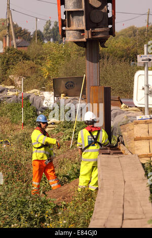 Burrowbridge, Somerset, UK. 30th September, 2014.  Environment Agency contractors install steel piling sheets to reinforce the river bank of the River Parrett as part of their flood prevention work to help protect the Somerset Levels from flooding. Stock Photo