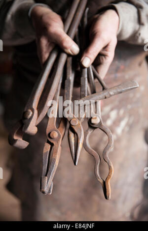 Traditional blacksmith holding his tools, Moretonhampstead, Dartmoor, Devon Stock Photo