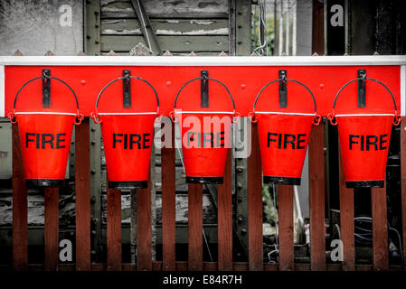 Five vintage firefighting buckets. Stock Photo