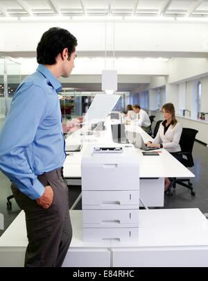young worker using a copy machine in office Stock Photo
