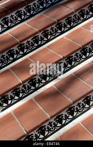 a selection of stone ceramic steps and patterned ceramic tiles with mottled shadows over them Stock Photo
