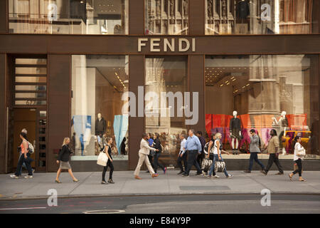 People walk along 5th Ave. in midtown Manhattan past many international designer stores. Stock Photo