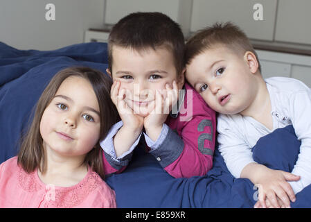 Young siblings relaxing together on bed, portrait Stock Photo