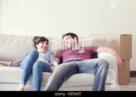 Couple relaxing on sofa while moving house Stock Photo