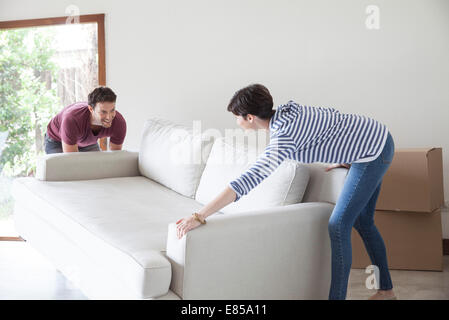 Couple moving sofa together Stock Photo