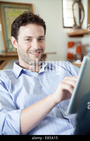 Man using digital tablet, smiling at camera Stock Photo