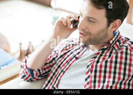 Man talking on cell phone at home Stock Photo