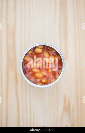 Open tin of Heinz Baked Beans on a wooden table