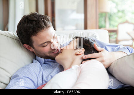 Couple relaxing together on sofa, preparing to kiss Stock Photo