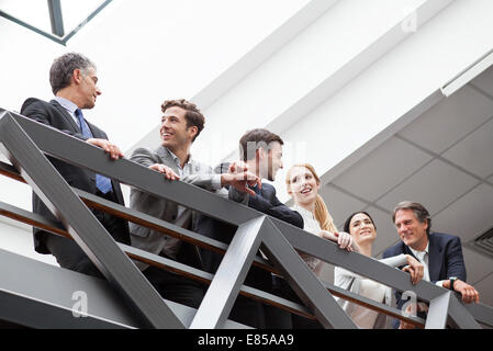 Team of executives talking together on balcony Stock Photo