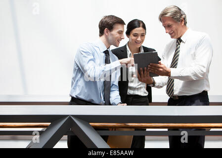 Business colleagues looking at digital tablet together Stock Photo
