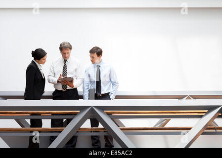 Executives looking at digital tablet together Stock Photo