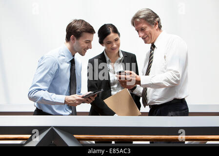 Businessman showing smartphone to colleagues Stock Photo