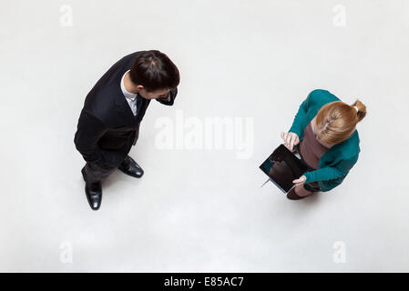Executives standing in lobby, woman using digital tablet, overhead view Stock Photo