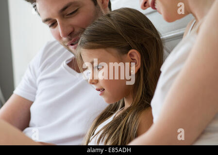 Parents and daughter reading together Stock Photo