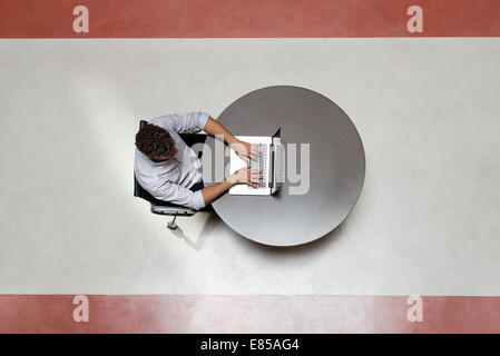College student using laptop computer alone in breakroom Stock Photo