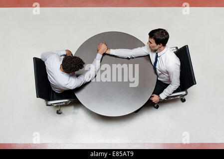 Businessman defeats colleague at arm wrestling match Stock Photo