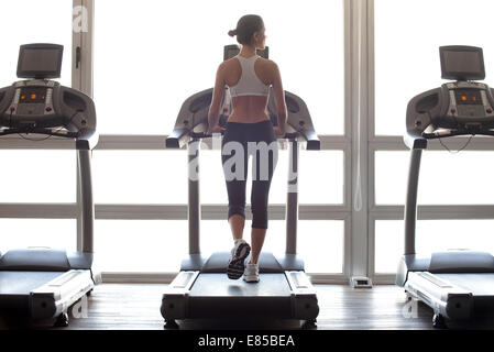 Woman jogging on treadmill at gym Stock Photo