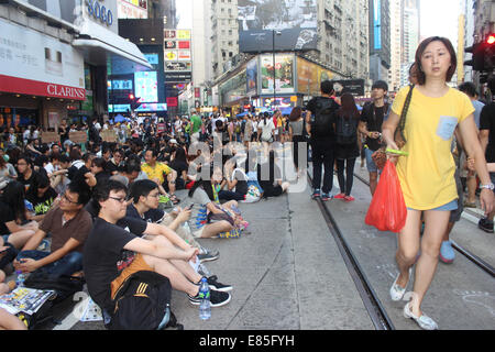 Hong Kong, 1 Oct, 2014.  Hong Kong Protests: A woman clutching a bag and a cell phone goes about her daily shopping next to pro-democracy protesters in the Causeway Bay shopping district near the Sogo department store. Credit:  Robert SC Kemp/Alamy Live News Stock Photo