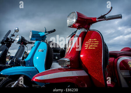 Vintage scooters, Vespas and Lambrettas parked together outside Stock Photo