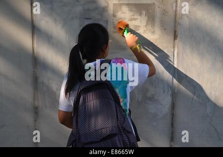 On Wednesday 1st October 2014, during a public holiday to mark the 65th anniversary of the founding of the People's Republic of China, slogans and graffiti are scrubbed off a wall by a protester, as thousands of young people participate in the fourth day of the pro-democracy protest known as 'Occupy Central', blocking traffic on major roads in downtown Hong Kong. The mood continues to be calm and non-violent, whereas three days earlier, protestors faced tear gas and pepper spray from police in full riot gear. Credit:  Stefan Irvine/Alamy Live News Stock Photo