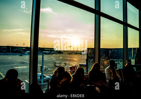 Passengers waiting to board aircraft in departure lounge at Stansted Airport UK Stock Photo