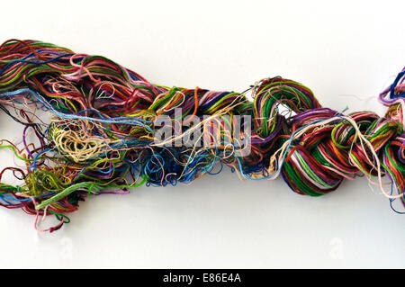 Tangled colorful sewing threads on white background. Stock Photo