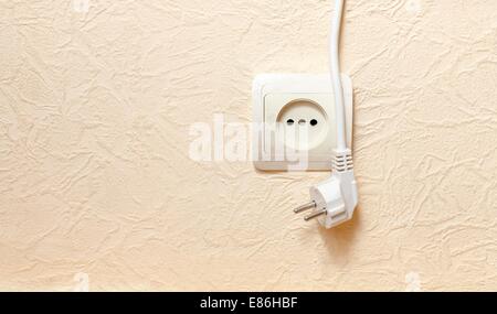 Electric wall plug at a beige wall Stock Photo