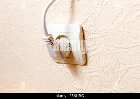 Electric wall plug at a beige wall Stock Photo
