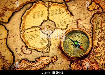 Vintage compass lies on an ancient map of the North Pole (also Hyperborea). Arctic continent on the Gerardus Mercator map of 1595. Stock Photo