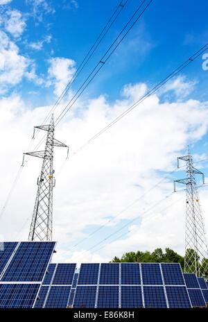 Solar panel and power lines over a blue cloudy sky Stock Photo - Alamy