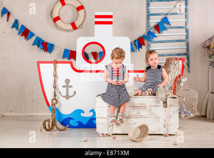 Two little girls play with seashells, sea theme. Stock Photo