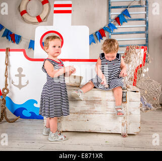 Two little girls play with seashells, sea theme. Stock Photo