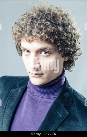 Very serious man. Detailed portrait of a young caucasian guy with curly hair Stock Photo