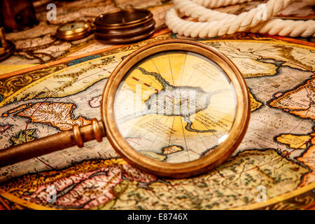 Vintage magnifying glass lies on the ancient map of the North Pole (also Hyperborea). Arctic continent on the Gerardus Mercator map of 1595. Stock Photo