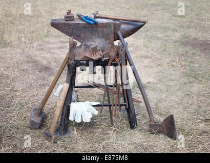 old anvil with many blacksmith tools Stock Photo