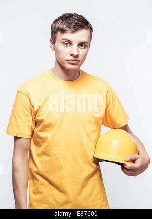 Male worker holding yellow helmet Stock Photo