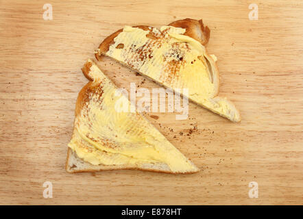 Slice of buttered toast on a wooden board Stock Photo