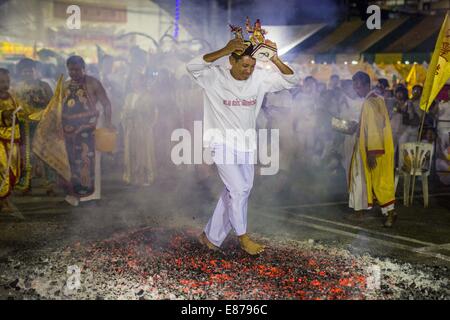 Bangkok, Thailand. 1st Oct, 2014. A man carries a religious statue while he runs through the fire pit during the firewalking ceremony at Wat Yannawa (also spelled Yan Nawa) during the Vegetarian Festival in Bangkok. The Vegetarian Festival is celebrated throughout Thailand. It is the Thai version of the The Nine Emperor Gods Festival, a nine-day Taoist celebration beginning on the eve of 9th lunar month of the Chinese calendar. Credit:  ZUMA Press, Inc./Alamy Live News Stock Photo