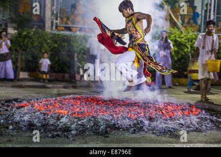 Bangkok, Thailand. 1st Oct, 2014. A man runs through the fire pit during the firewalking ceremony at Wat Yannawa (also spelled Yan Nawa) during the Vegetarian Festival in Bangkok. The Vegetarian Festival is celebrated throughout Thailand. It is the Thai version of the The Nine Emperor Gods Festival, a nine-day Taoist celebration beginning on the eve of 9th lunar month of the Chinese calendar. Credit:  ZUMA Press, Inc./Alamy Live News Stock Photo