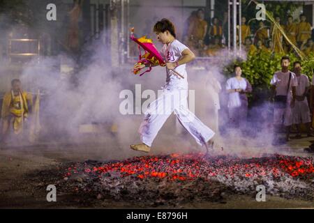 Bangkok, Thailand. 1st Oct, 2014. A man runs through the fire pit during the firewalking ceremony at Wat Yannawa (also spelled Yan Nawa) during the Vegetarian Festival in Bangkok. The Vegetarian Festival is celebrated throughout Thailand. It is the Thai version of the The Nine Emperor Gods Festival, a nine-day Taoist celebration beginning on the eve of 9th lunar month of the Chinese calendar. Credit:  ZUMA Press, Inc./Alamy Live News Stock Photo