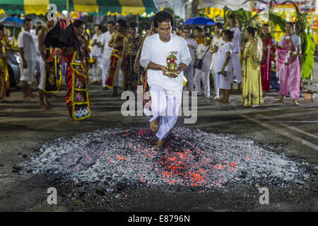 Bangkok, Thailand. 1st Oct, 2014. A man carries a religious statue while he runs through the fire pit during the firewalking ceremony at Wat Yannawa (also spelled Yan Nawa) during the Vegetarian Festival in Bangkok. The Vegetarian Festival is celebrated throughout Thailand. It is the Thai version of the The Nine Emperor Gods Festival, a nine-day Taoist celebration beginning on the eve of 9th lunar month of the Chinese calendar. Credit:  ZUMA Press, Inc./Alamy Live News Stock Photo