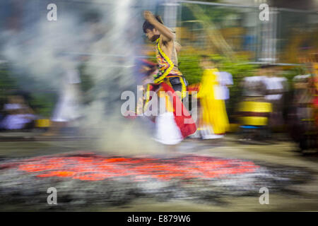 Bangkok, Thailand. 1st Oct, 2014. A man runs through the fire pit during the firewalking ceremony at Wat Yannawa (also known as Yan Nawa) during the Vegetarian Festival. The Vegetarian Festival is celebrated throughout Thailand. It is the Thai version of the The Nine Emperor Gods Festival, a nine-day Taoist celebration beginning on the eve of 9th lunar month of the Chinese calendar. During a period of nine days, those who are participating in the festival dress all in white and abstain from eating meat, poultry, seafood, and dairy products. Credit:  Jack Kurtz/ZUMA Wire/Alamy Live News Stock Photo