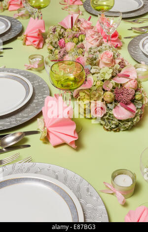 Beautiful twotone flower arrangement in soft pink and green on a christmas dinner table Stock Photo