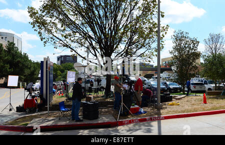 Houston, USA. 1st Oct, 2014. Journalists gather outside Texas Health Presbyterian Hospital in the northern Texas city of Dallas, the United States, Oct. 1, 2014. Officials from the U.S. state of Texas confirmed on Wednesday that five students who had contact with the man diagnosed with Ebola are being monitored and the patient's condition had been upgraded from critical to serious. Credit:  Xu Xun/Xinhua/Alamy Live News Stock Photo