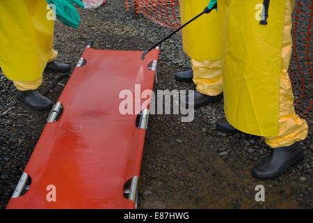 The team in charge of burning the bodies of Ebola victims disenfect a stretcher shortly after loading a number of bodies into th Stock Photo
