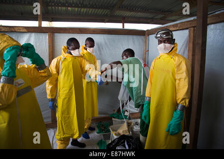 The team in charge of burning the bodies of Ebola victims dress in PPE before transporting the bodies from a truck to the incine Stock Photo