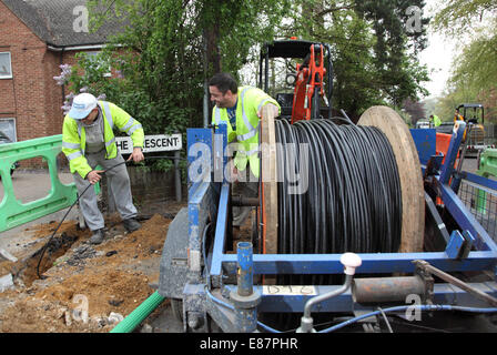 Workmen install new optical cables for high speed broadband in a rural street in southern England Stock Photo